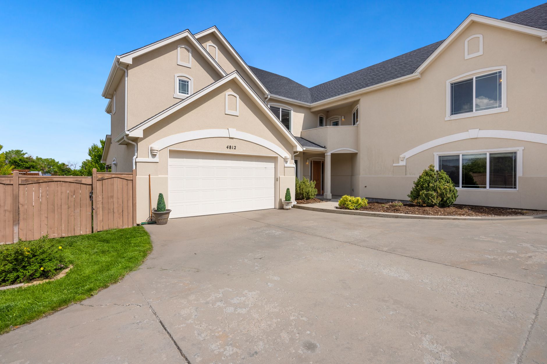 Two car steel garage door on a brick Plano home with the torsion spring and opener rail visible inside